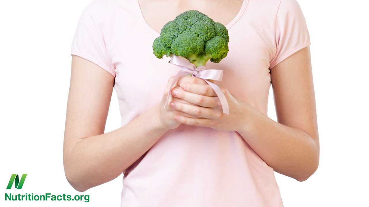 le légume de survie au cancer du sein réprésenté par un brocoli dans les mains d'une femme